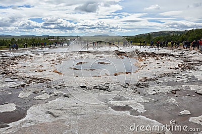 Strokkur geyser just before erupting and many tourists waiting Editorial Stock Photo