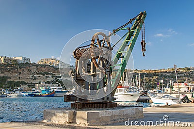Ghajnsielem, Malta - May 8, 2017: Mgarr Harbour promande with historic crane at Gozo island. Editorial Stock Photo