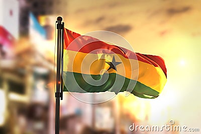 Ghana Flag Against City Blurred Background At Sunrise Backlight Stock Photo