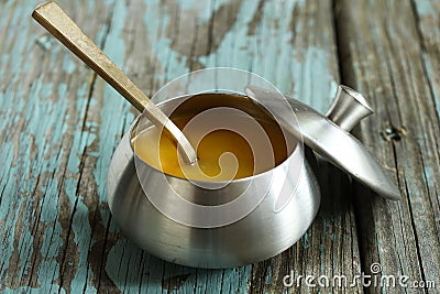 Ghee / Clarified butter on rustic blue background, selective focus Stock Photo