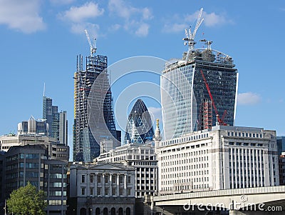 The `Gherkin` between two skyscrapers under construction in the City of London Editorial Stock Photo