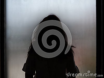 Ghost girl silhouette standing in front of window Stock Photo