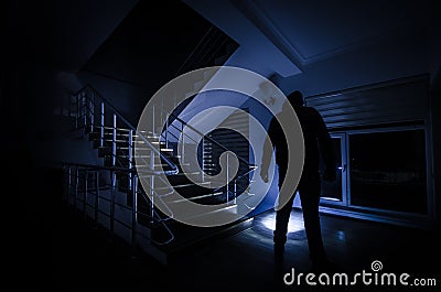 Ghost in Haunted House at stairs, Mysterious silhouette of ghost man with light at stairs, Horror scene of scary ghost spooky llig Stock Photo