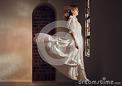 Ghost of senior woman, looking at stained glass and floating over floor of building or cathedral. Elderly soul, phantom Stock Photo