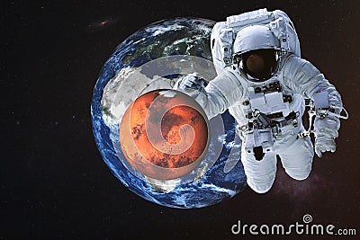 Giant astronaut near Mars and Earth planets Stock Photo