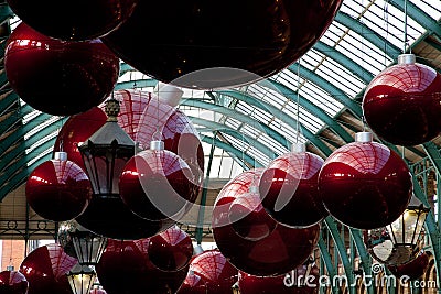 Giant christmas baubles hung from the roof of Covent Garden in London Editorial Stock Photo