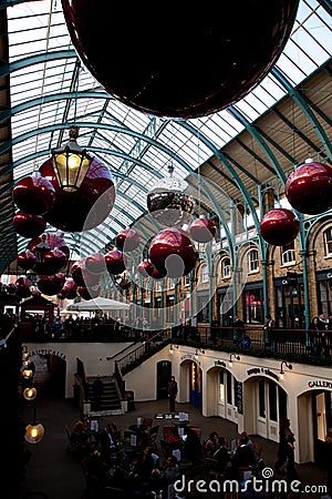 Giant christmas baubles hung from the roof of Covent Garden in London Editorial Stock Photo