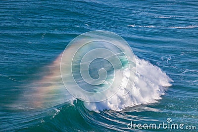 Giant Ocean Wave with Rainbow in Spray Stock Photo