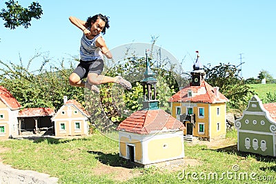 Giant girl hitting belfry in Minimodel of South Bohemian village Stock Photo