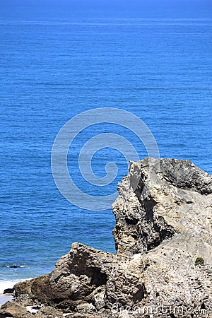 Giant rockfall in the calm sea Stock Photo