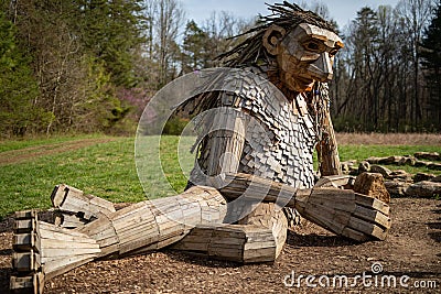 Giant wooden sculpture of a man sitting in Bernheim Arboretum and Research Forest in Louisvill Editorial Stock Photo