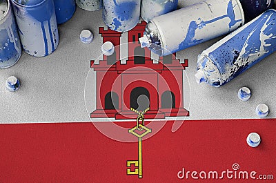 Giblartar flag and few used aerosol spray cans for graffiti painting. Street art culture concept Stock Photo