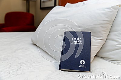 Gideons Bible on bed in hotel room Editorial Stock Photo