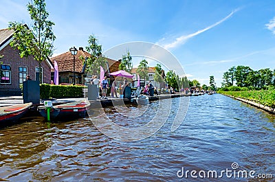 GIETHOORN, NETHERLANDS - JULY 17,2016: Tourists renting boats on the canal between houses in the famous village of Giethoorn, The Editorial Stock Photo