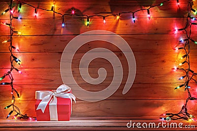 Gift box with christmas light and wooden background. Stock Photo