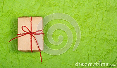 Gift box on a green background. Simple gift wrapping. Recycled paper. Stock Photo