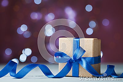 Gift box or present against festive bokeh background. Holiday greeting card for Christmas, New Year or birthday. Stock Photo