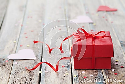 Gift box with red bow ribbon and paper heart on table for Valentines day Stock Photo