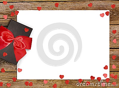 Gift box with red bow ribbon and paper heart on wooden background for Valentines day Stock Photo