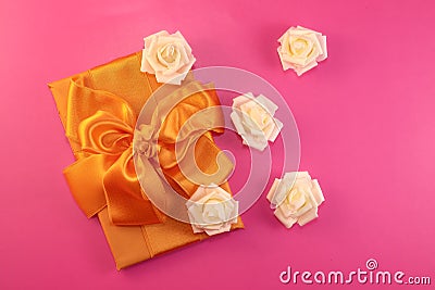 Gift box with rose flowers on pink background. flat lay Stock Photo