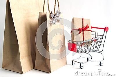 Gift box on shopping cart and shopping bags on white background Stock Photo