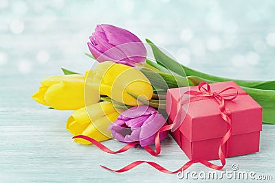 Gift box and tulip flowers on rustic table for March 8, International Womens day, Birthday or Mothers day Stock Photo