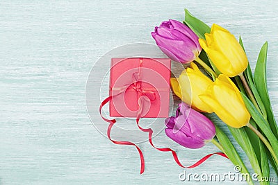 Gift box and tulip flowers on rustic table for March 8, International Womens day, Birthday or Mothers day Stock Photo