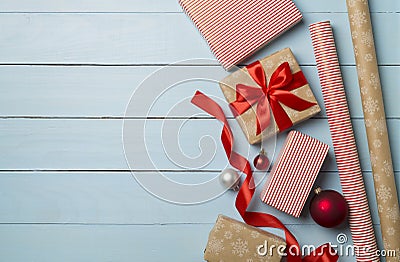 Gift boxes, paper's rools and decorations on wooden background, top view Stock Photo