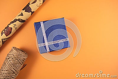 Gift boxes paper's rools and rope on orange backgruond Stock Photo