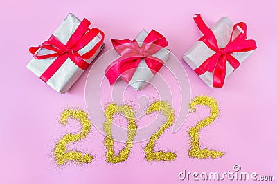Gift boxes with ribbon on a pink background and the inscription 2022 Stock Photo