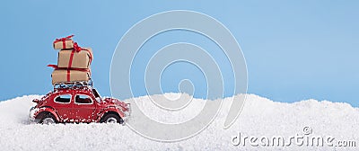 Gift boxes on toy vintage car Volkswagen Beetle over snowy Christmas background Editorial Stock Photo