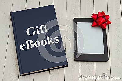 Retro old blue book on a desk with an ereader with gift bow Stock Photo