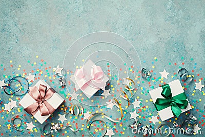 Gift or present box decorated colorful confetti, star and streamer on blue vintage table top view. Flat lay style. Birthday. Stock Photo