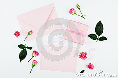 Gift or present box, envelope, paper blank and pink rose flower on white table top view in flat lay style for greeting card. Stock Photo