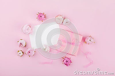 Gift or present box, white paper blank and spring flower on pink desk from above for wedding mockup or greeting card on womans day Stock Photo