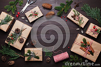 Gift or present box wrapped in kraft paper with christmas decoration on rustic wooden background from above. Flat lay style. Stock Photo