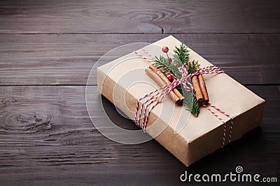 Gift or present box wrapped in kraft paper with christmas decoration on vintage wooden table. Copy space for text. Stock Photo