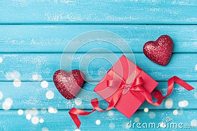 Gift and red heart on turquoise wooden background top view. Saint valentine day greeting card. Stock Photo