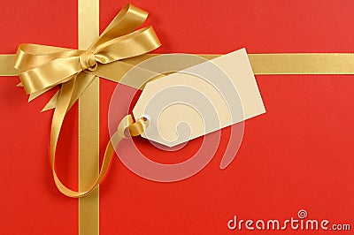 Gift tag or label, red background, gold ribbon bow, copy space, Christmas present or gift Stock Photo