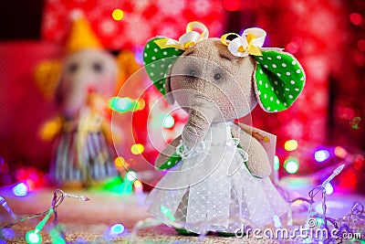 Gift toy elephant standing on background of Christmas lights and boxes Stock Photo