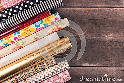 Gift wrapping paper rolls on wooden table with copy space Stock Photo