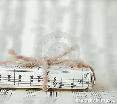 Giftbox on music sheet. A musical gift on notes background Stock Photo