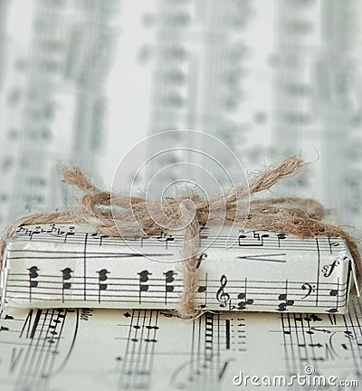 Giftbox on music sheet. A musical gift on notes background Stock Photo