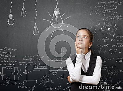 Gifted pretty young girl near blackboard with formulas. Stock Photo