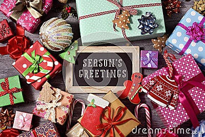 Gifts, christmas ornaments and text seasons greetings Stock Photo