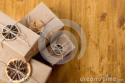 Gifts decorated with dry citrus on wooden background top view Stock Photo