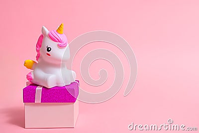 Gifts, unicorn figurine and gift box for a party on a pink background Stock Photo