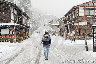 Female tourist holding transparent umbrella and walking on the street with background of Shirakawa-go village Editorial Stock Photo