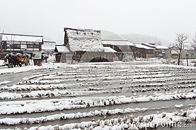 Tourist walking on the street with background of Ancient houses and snow-covered rice fields of Shirakawa-go village at Gifu, Japa Editorial Stock Photo