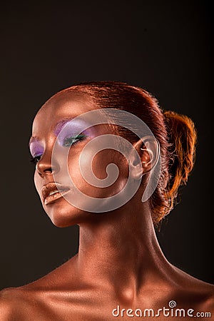 Gilt. Golden Woman's Face Closeup. Futuristic Gilded Make-up. Painted Skin bronze. Stock Photo